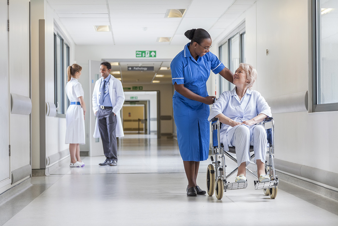 nurse talking to a woman in a wheel chair in a hospital