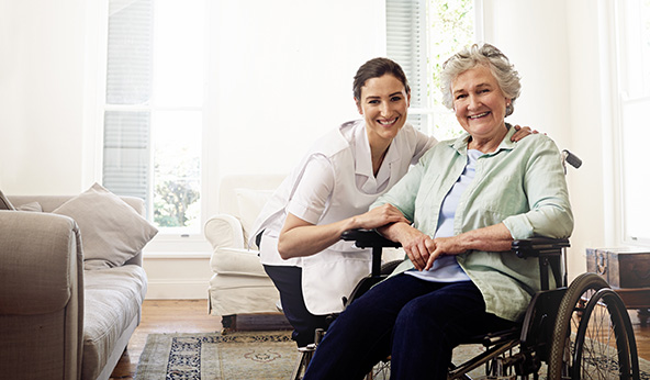 nurse sat next to an elderly lady, with both smiling